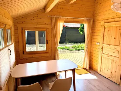a wooden room with a table and chairs at The Bee - Trekkershuts & Apartment in Opperdoes
