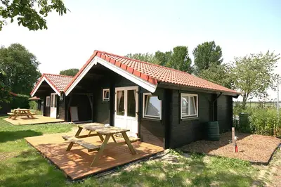 a small cabin with a picnic table in the yard at The Bee - Trekkershuts & Apartment in Opperdoes