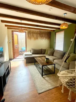 a living room with a couch and a hammock at Sandy soul escape in Zandvoort