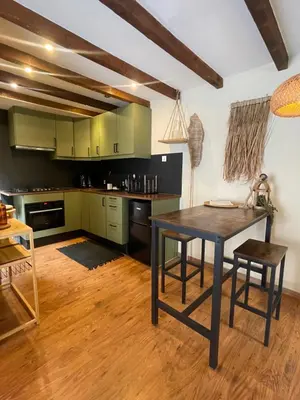 a kitchen with green cabinets and a wooden table at Sandy soul escape in Zandvoort