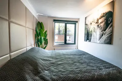 a bedroom with a bed and a window at Amsterdam-Houseboat-Amstel in Amsterdam