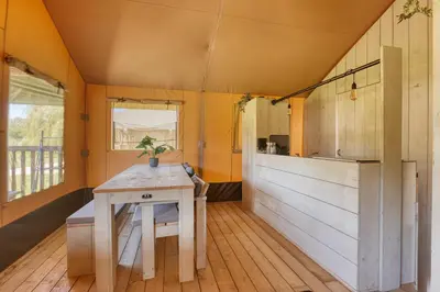 a kitchen with a wooden table in a room at Trio Lodge in Zeewolde