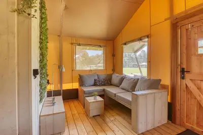 a living room with a couch in a house at Trio Lodge in Zeewolde