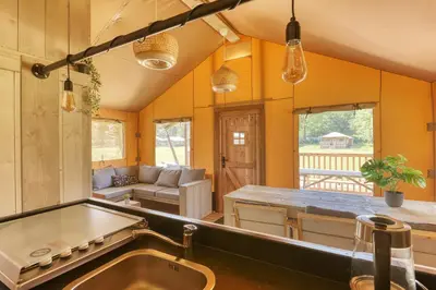 a kitchen and living room with a sink and a couch at Trio Lodge in Zeewolde