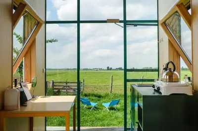 a kitchen with a large window with a view of a field at Hihahut De Tuureluur in Oud-Ade