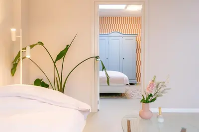 a bedroom with a bed and a mirror at Nice bright studio near the forest and Amsterdam in Baarn