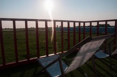 a couple of chairs on a balcony with the sun at Hihahut De Zonnepost in Oud-Ade