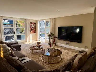 a living room with a couch and a flat screen tv at Vakantiewoning Casa Bergen Home in Bergen