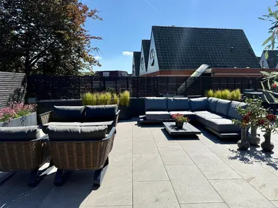 a patio with a couch and chairs on a patio at Vakantiewoning Casa Bergen Home in Bergen