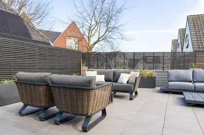 a patio with wicker chairs and couches at Vakantiewoning Casa Bergen Home in Bergen
