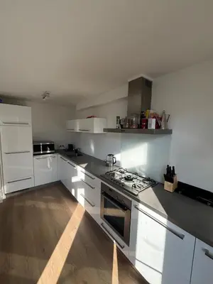 a kitchen with white cabinets and a stove top oven at Cozy Home in The Oude Pijp in Amsterdam