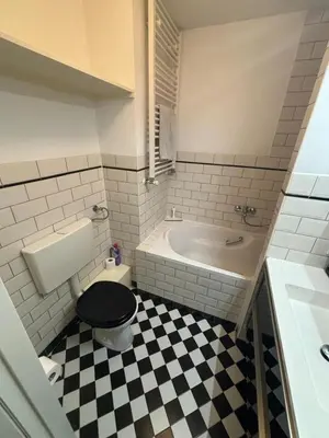 a bathroom with a black toilet and a bath tub at Cozy Home in The Oude Pijp in Amsterdam