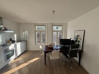 a kitchen with a table with chairs and a desk at Cozy Home in The Oude Pijp in Amsterdam