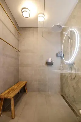 a shower with a wooden bench in a bathroom at La Casa Goudacito in Gouda