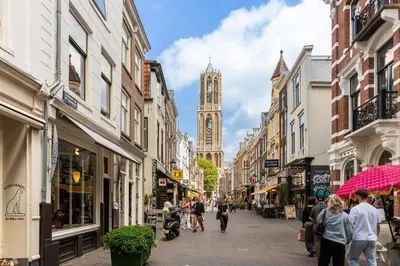 a city street with a clock tower in the distance at Unique underground hotel in Utrecht city center in Utrecht
