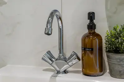 a sink with a soap dispenser and a bottle of liquid at Unique underground hotel in Utrecht city center in Utrecht