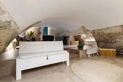 a living room with a white couch and a stone wall at Unique underground hotel in Utrecht city center in Utrecht