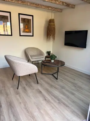 a living room with a couch and a table and a tv at BeachHouse ibiza 19A in Noordwijk aan Zee