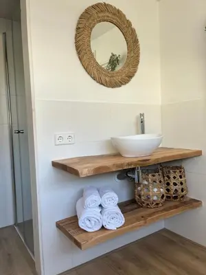 a bathroom with a sink and a mirror and towels at BeachHouse ibiza 19A in Noordwijk aan Zee