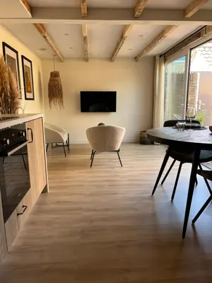 a living room with a table and chairs and a tv at BeachHouse ibiza 19A in Noordwijk aan Zee