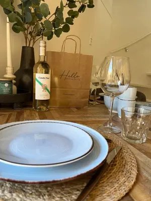a table with a plate and a bottle of wine at BeachHouse ibiza 19A in Noordwijk aan Zee