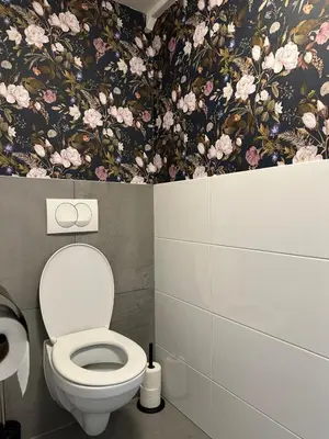 a bathroom with a toilet and floral wallpaper at Catwijck Loft in Katwijk aan Zee