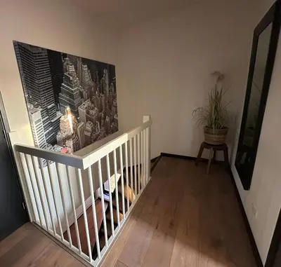 a room with a staircase with a painting on the wall at Catwijck Loft in Katwijk aan Zee