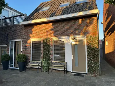 a brick building with two benches in front of it at Catwijck Loft in Katwijk aan Zee