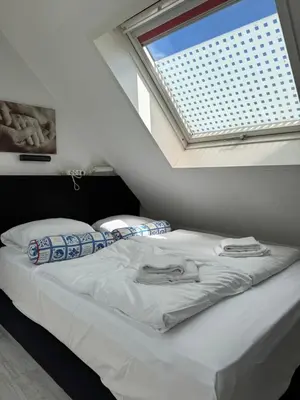 a bed in a room with a window at Zomerhuisje Maranatha in Noordwijk aan Zee