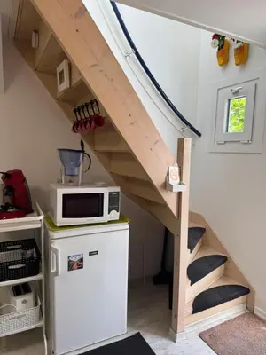 a staircase in a tiny house with a microwave at Zomerhuisje Maranatha in Noordwijk aan Zee