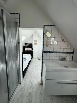 a bathroom with a tub and a sink and a bed at Zomerhuisje Maranatha in Noordwijk aan Zee