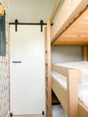 a bunk room with two bunk beds and a door at The Kingfisher near beach and dunes Hargen and Schoorl in Dirkshorn