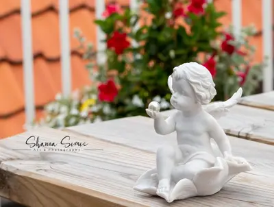 a white angel statue sitting on a table with flowers at ApartHotel De Koning by Urban Home Stay in Alkmaar
