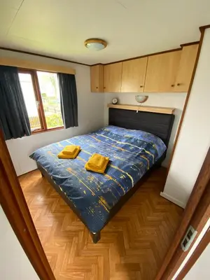 a bedroom with a bed with two yellow towels on it at Geniet van de rust en de ruimte in Bodegraven