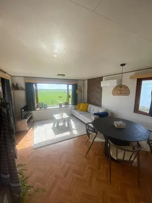 a living room with a couch and a table at Geniet van de rust en de ruimte in Bodegraven