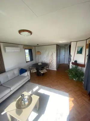 a living room with a couch and a table at Geniet van de rust en de ruimte in Bodegraven