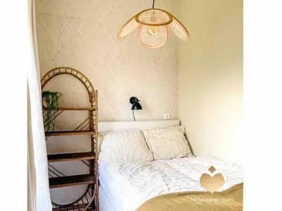 a small bedroom with a bed and a ceiling fan at The Soultree - Stylish nature cottage near Schoorl dunes & Bergen beach in Warmenhuizen