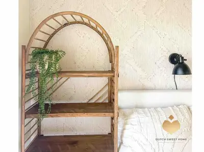 a wooden shelf with a plant on it next to a bed at The Soultree - Stylish nature cottage near Schoorl dunes & Bergen beach in Warmenhuizen