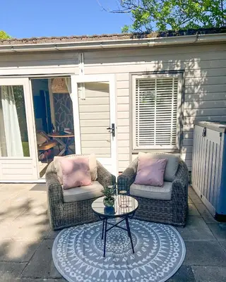 two couches and a table on a patio at The Soultree - Stylish nature cottage near Schoorl dunes & Bergen beach in Warmenhuizen