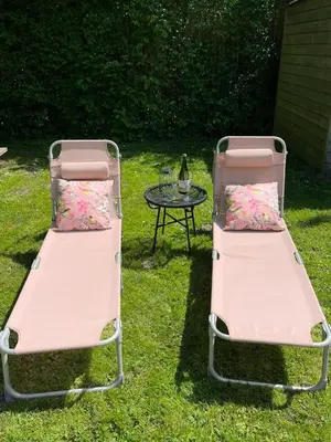 two pink beds sitting next to a table at The Soultree - Stylish nature cottage near Schoorl dunes & Bergen beach in Warmenhuizen