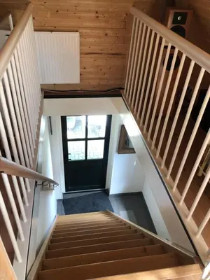 a staircase in a house with wooden ceilings at kleinrosenbrand in Burgerbrug
