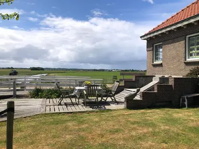a deck with a table and chairs on a house at kleinrosenbrand in Burgerbrug