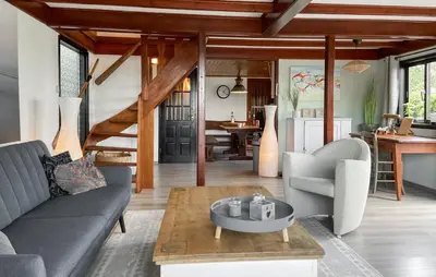 a living room with a couch and a table at Woonboot De Karekiet in Loosdrecht