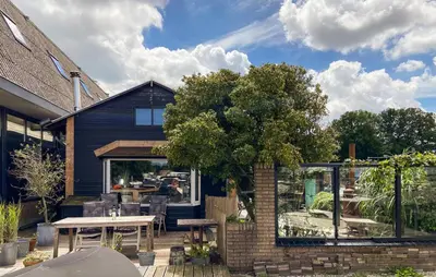 a patio with a table and a tree at Woonboot De Karekiet in Loosdrecht