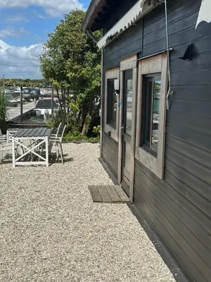 a building with a window and a table next to it at Woonboot De Karekiet in Loosdrecht