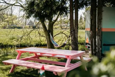 a picnic table and a hammock in a park at SRV wagen De Geus in Oud-Ade