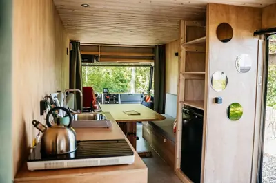 a kitchen in a tiny house with a tea kettle on the stove at SRV wagen De Geus in Oud-Ade