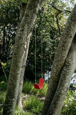 a red seat swing hanging between two trees at SRV wagen De Geus in Oud-Ade