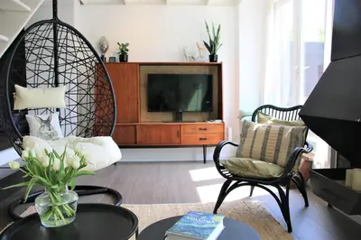 a living room with a tv and two chairs and a table at The Highlander- Stylish Hideaway near Beach & Forest Schoorl and Bergen- Dogs Welcome in Warmenhuizen