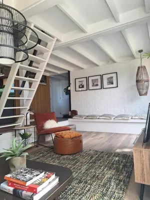 a living room with a staircase and a table at Rekerlanden 32 in Schoorldam